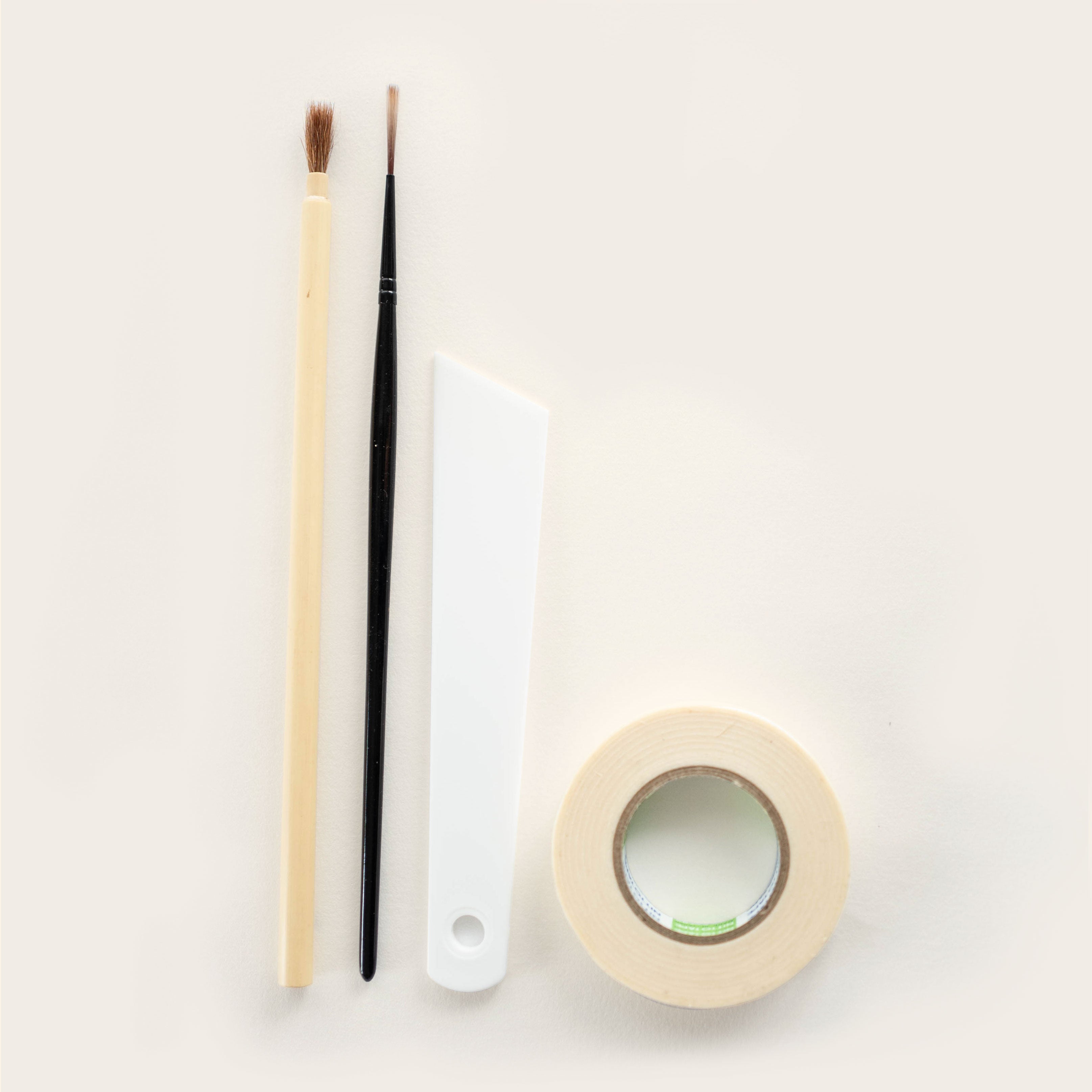 Two brushes, spatula and masking tape